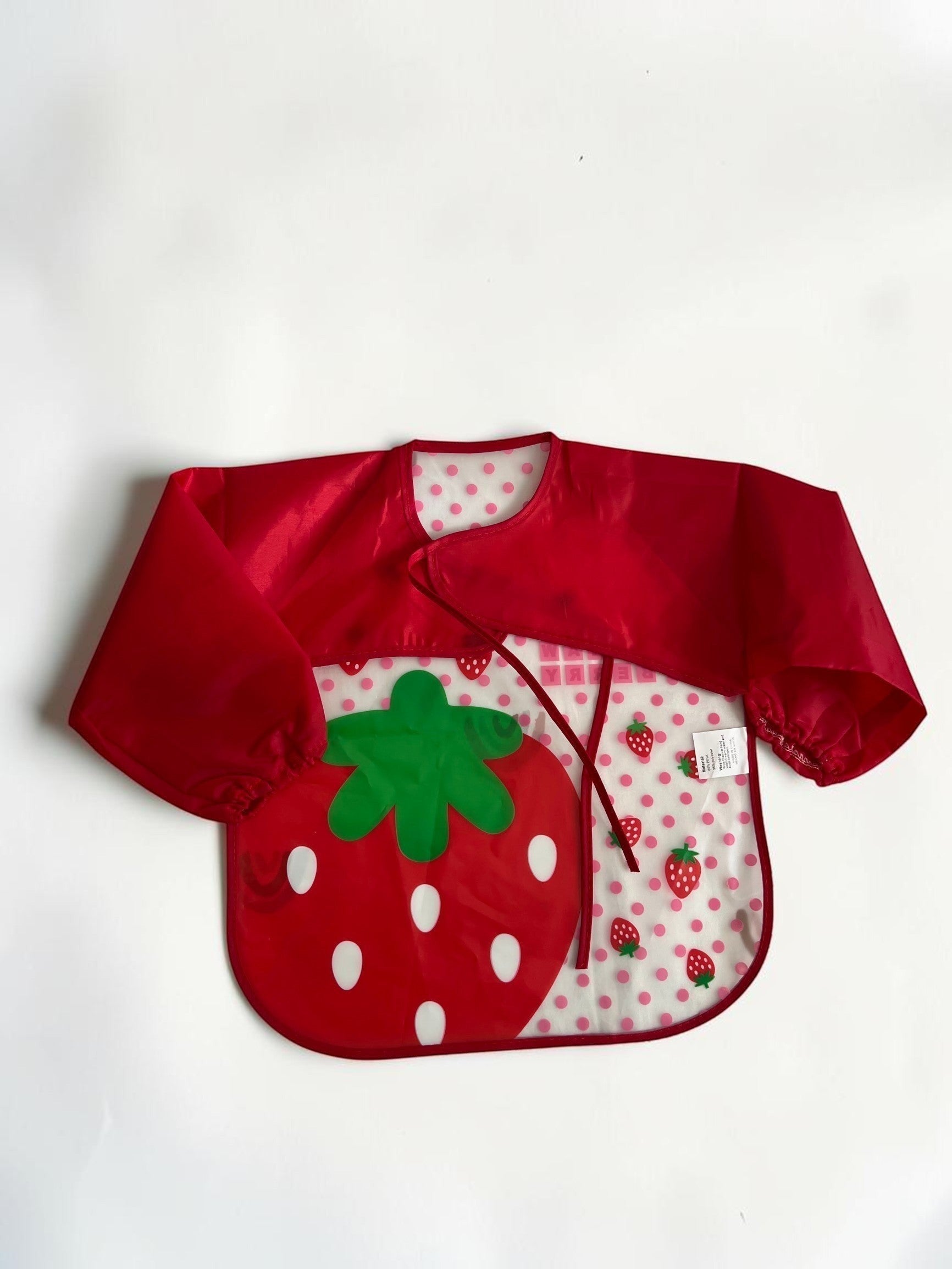 Babero rojo de manga larga Vamos Niños con estampado de fresas y lunares rosas. Material impermeable, ideal para la hora de comer.