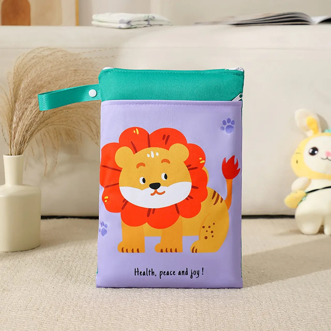 Bolsa impermeable Vamos Niños color lila con estampado de león, cremallera y asa con botón para organizar accesorios.
