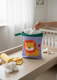 Bolsa impermeable Vamos Niños con estampado de león, color lila y verde, ideal para organizar pañales y ropa.