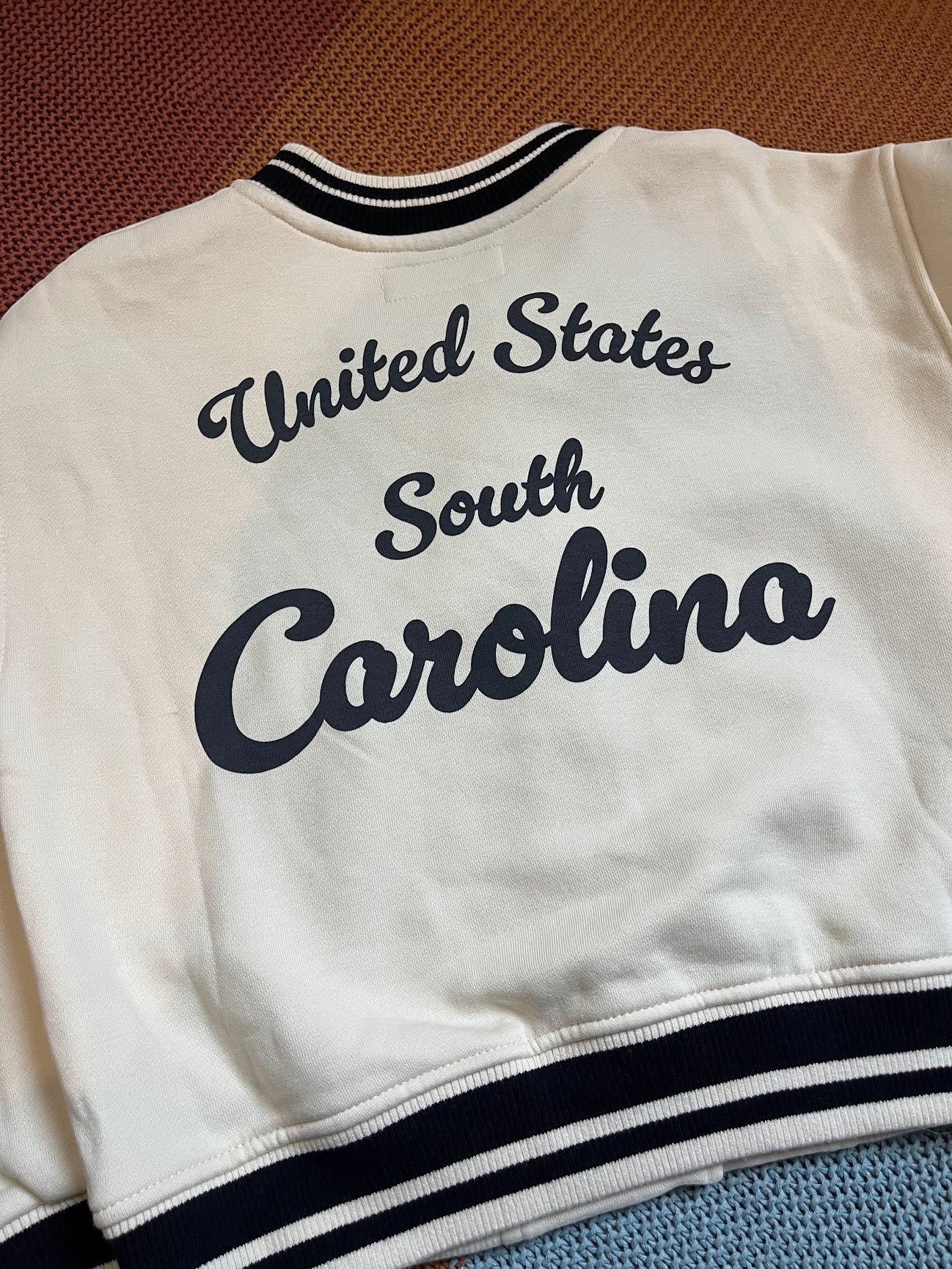 Chaqueta universitaria beige de Vamos Niños para niño con letras estampadas en la espalda y detalles en negro