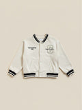 Chaqueta universitaria beige de Vamos Niños marca Lefties con letras bordadas y detalles en negro en puños y cuello