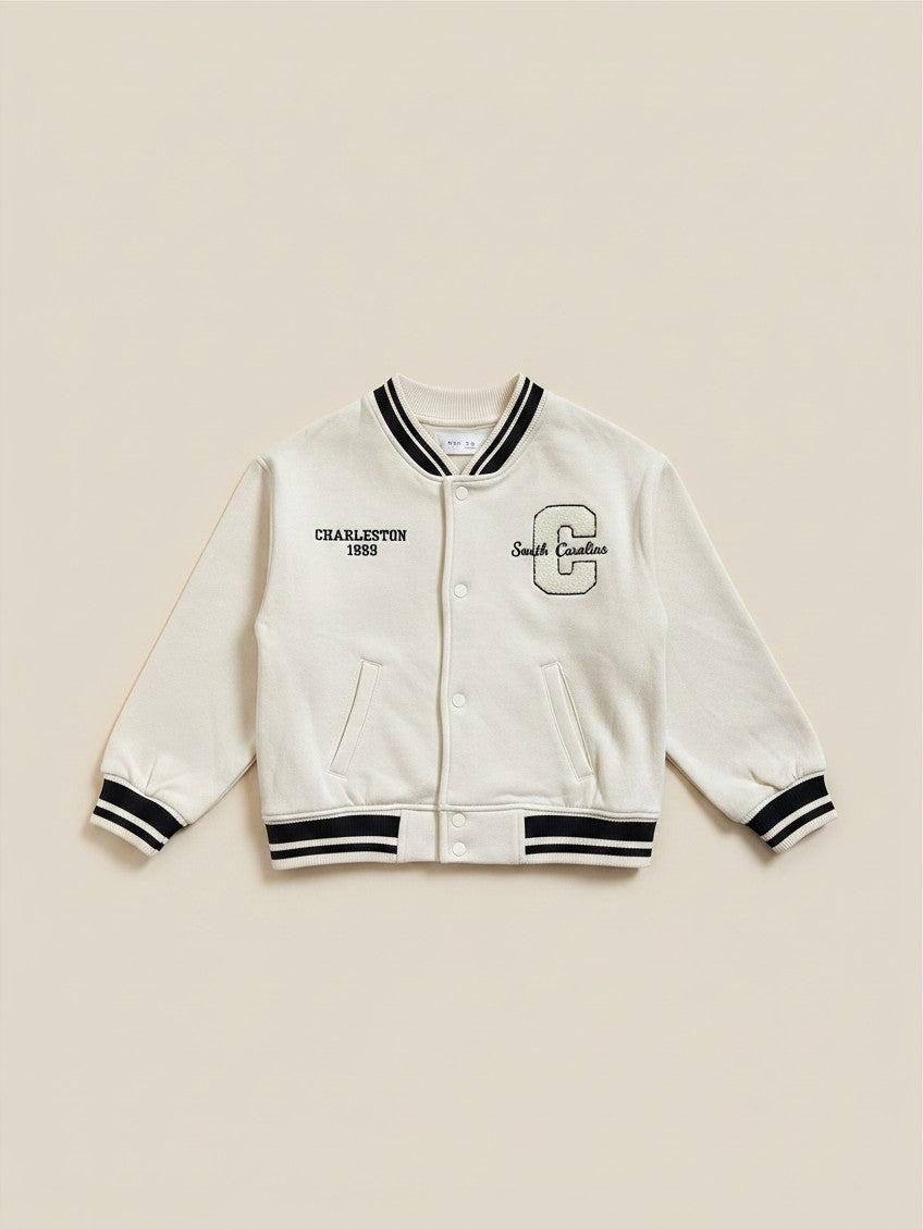 Chaqueta universitaria beige de Vamos Niños marca Lefties con letras bordadas y detalles en negro en puños y cuello