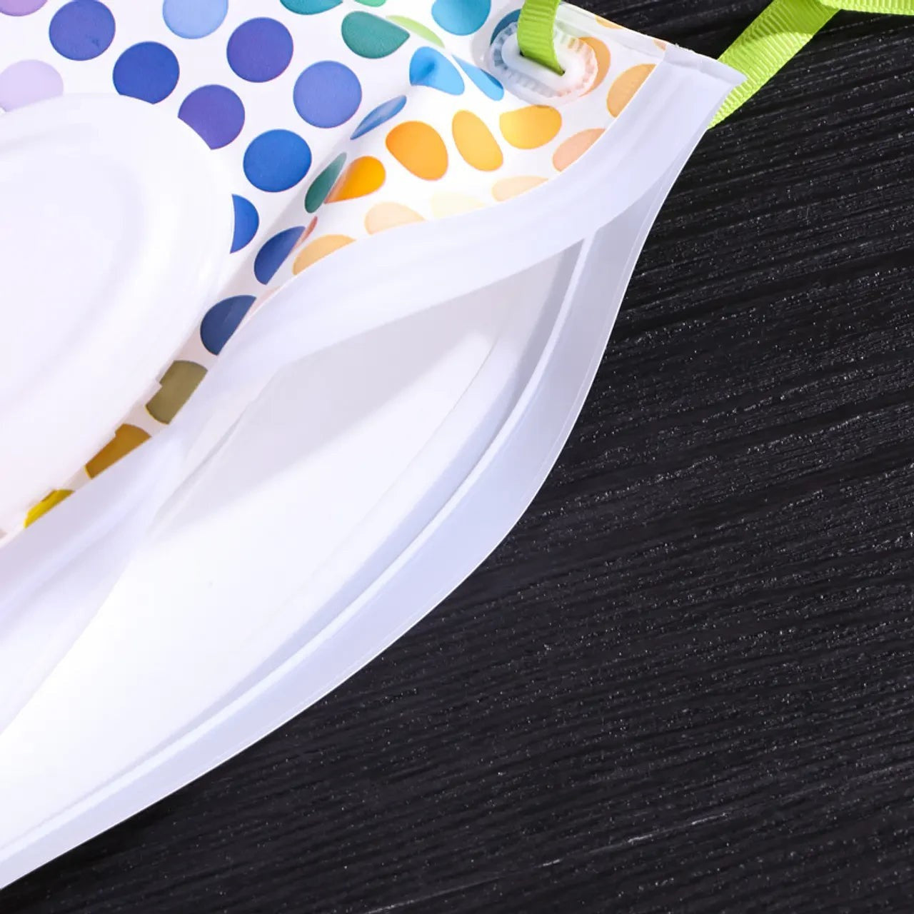 Estuche portátil para toallitas Vamos Niños con estampado de lunares coloridos, tapa blanca y correa de transporte.