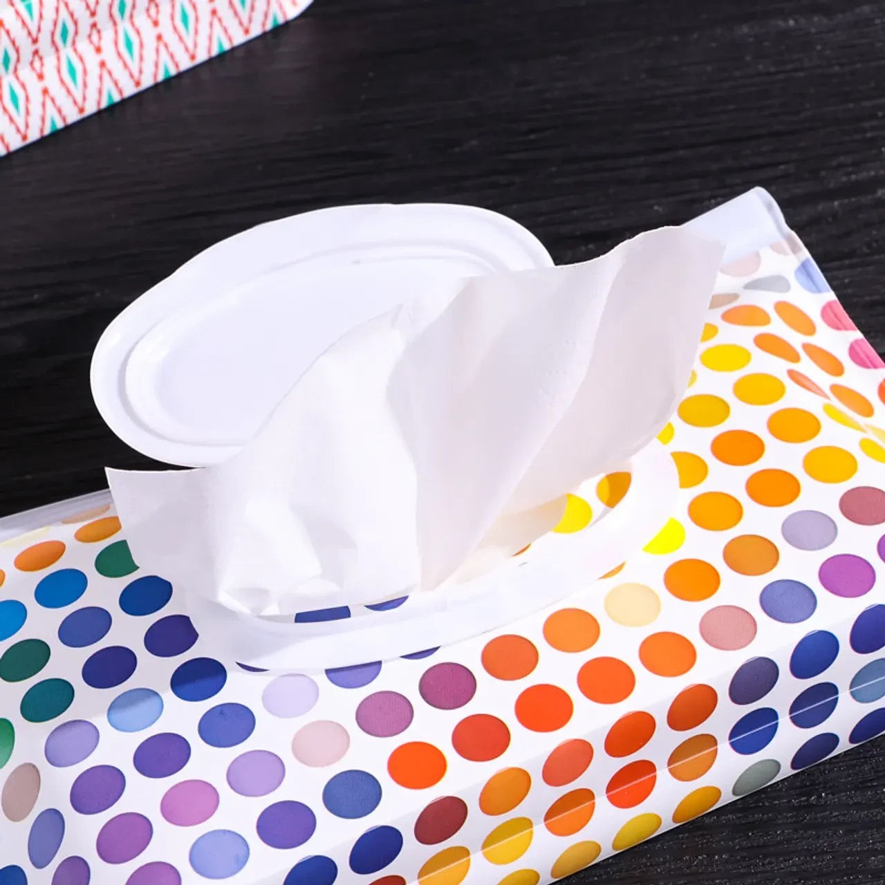 Estuche portátil para toallitas húmedas Vamos Niños con estampado de lunares coloridos y tapa abatible blanca.