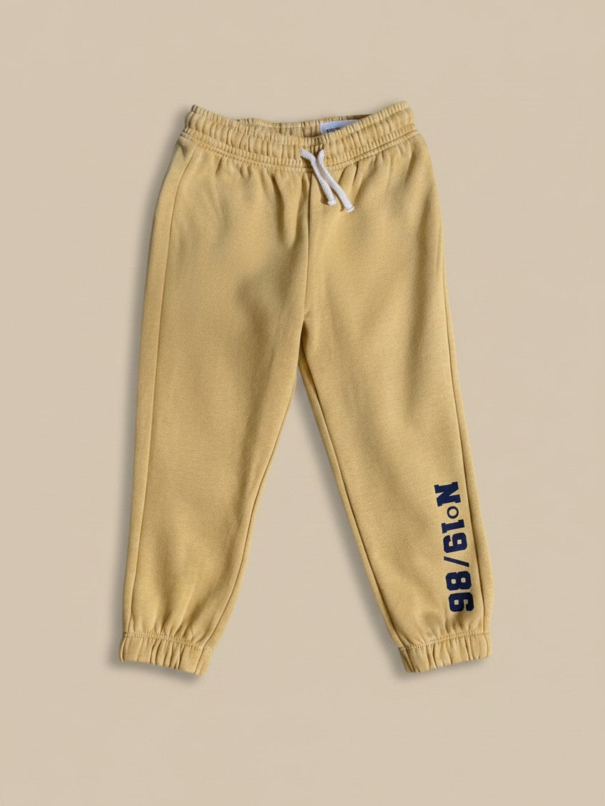 Pantalón de buzo amarillo Vamos Niños de Lefties con letras negras en el tobillo y cintura elástica con cordón