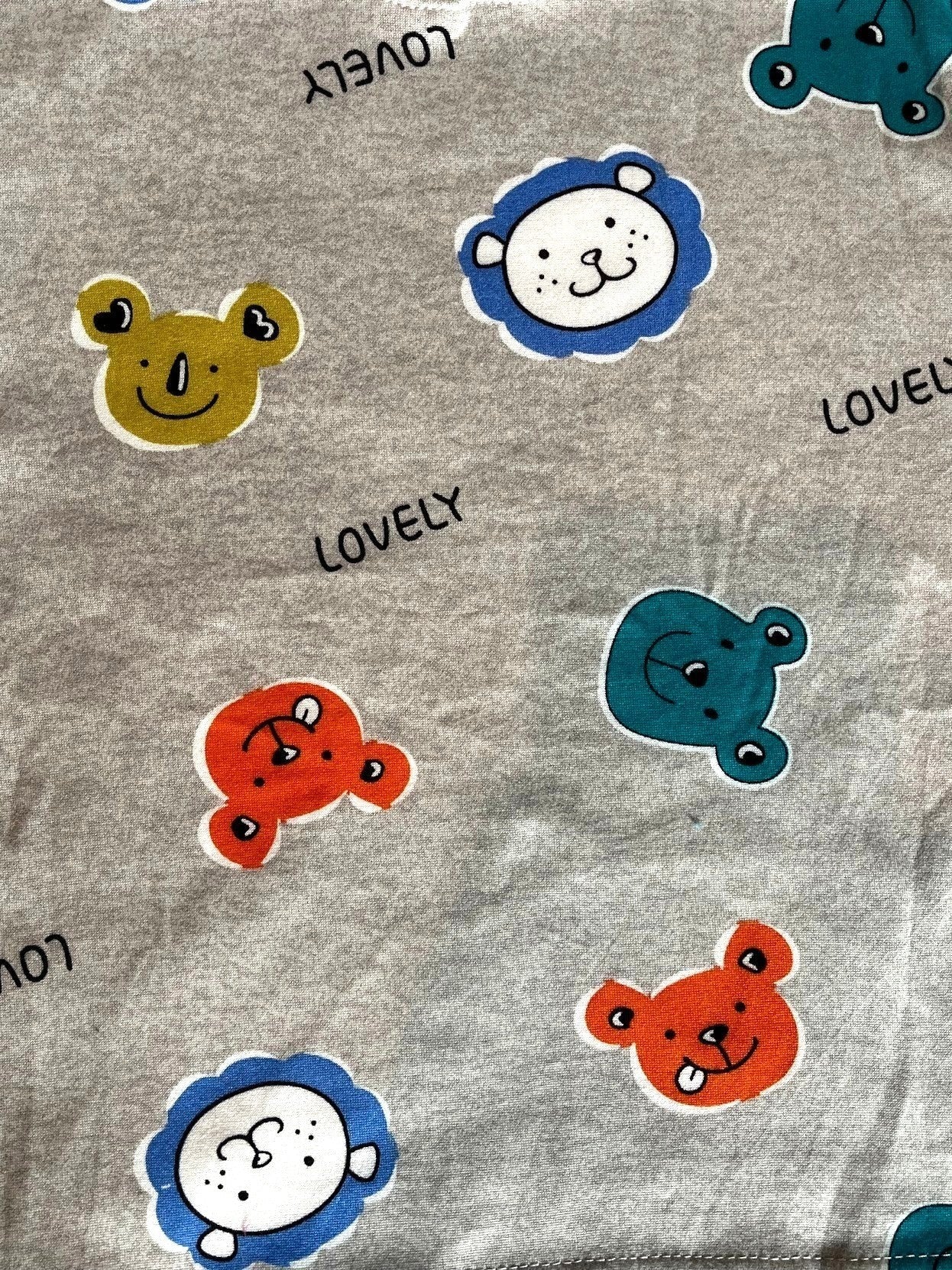Tela de pijama Vamos Niños gris afranelada con estampado de caritas de osos y animales coloridos y texto Lovely