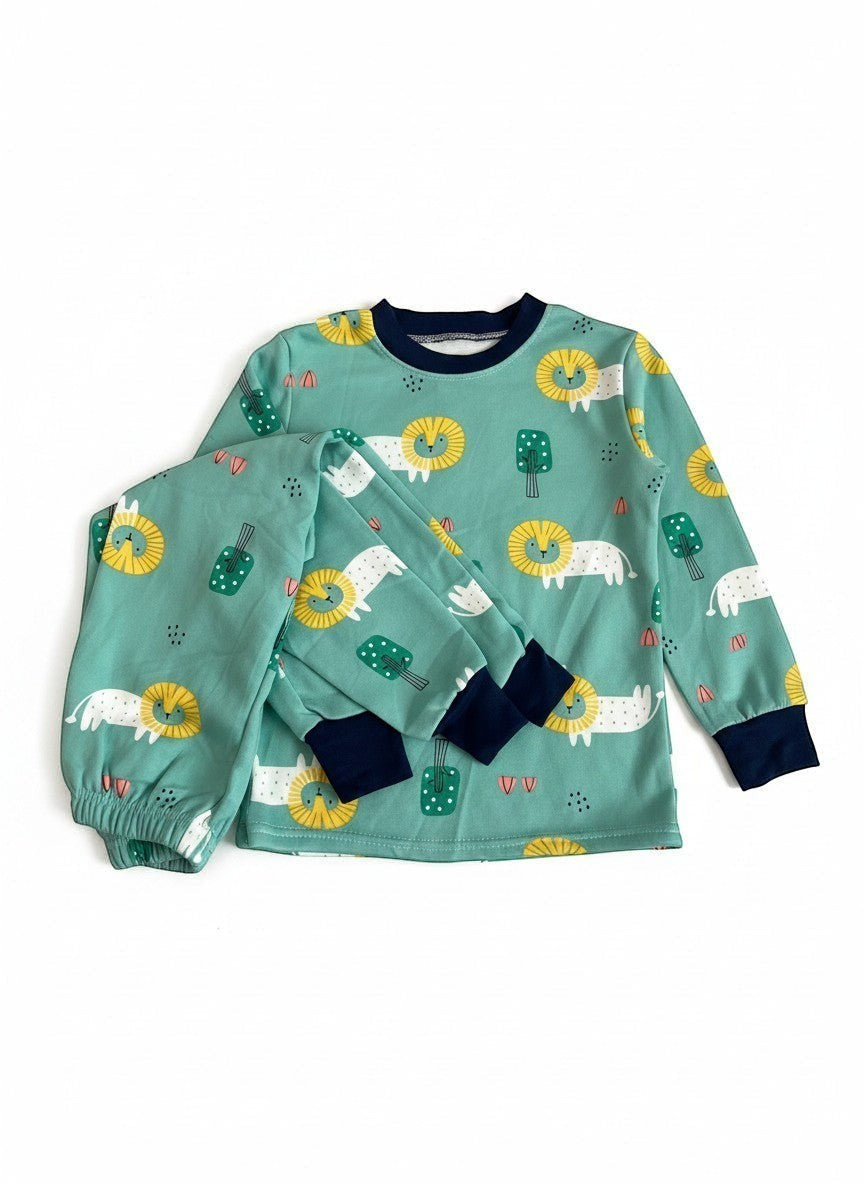 Pijama Vamos Niños con estampado de leones y árboles. Puños y cuello azul marino.