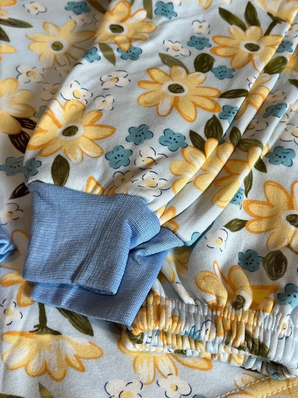 Pijama infantil Vamos Niños con estampado floral amarillo y azul, puños de canalé y tejido suave de algodón.