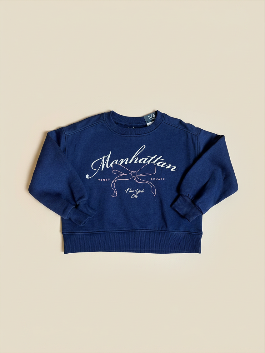 Polerón azul de niña Vamos Niños Lefties con estampado de lazo y letras Manhattan en el frente