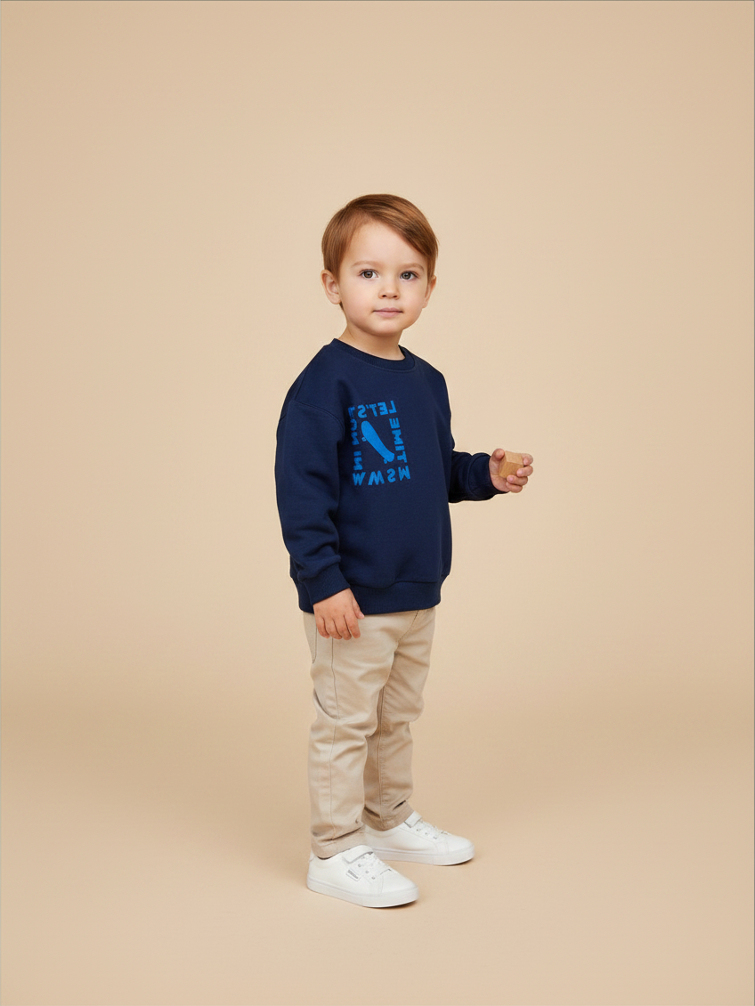 Niño pequeño vistiendo polerón azul oscuro Lefties con estampado de Vamos Niños sobre fondo beige