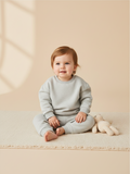 Bebé sentado con conjunto de polerón y pantalón gris de Vamos Niños, estilo casual y cómodo