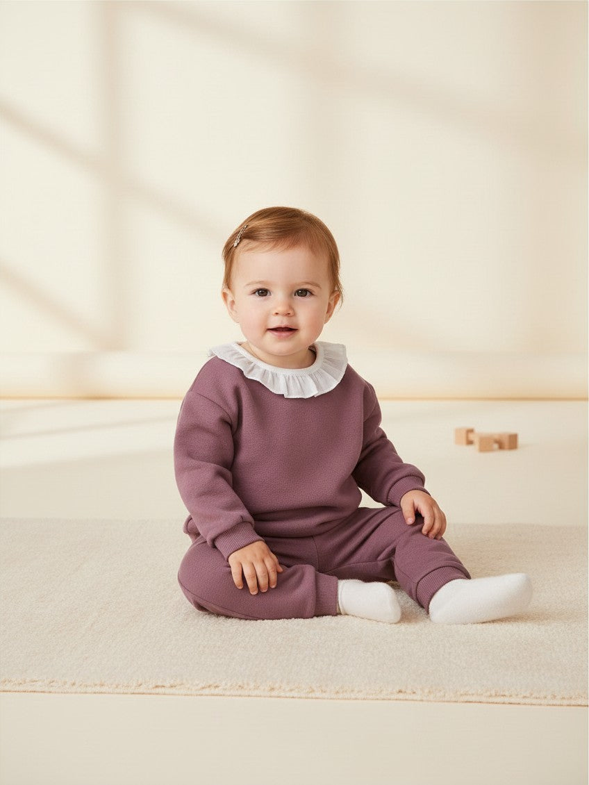 Bebé con polerón morado de Vamos Niños con cuello blanco, estilo casual y cómodo para niña de 12 meses