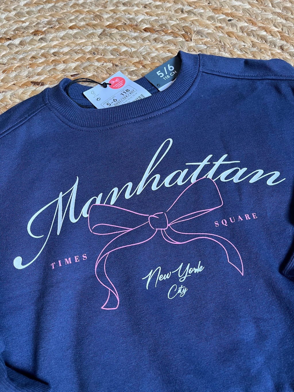 Polerón azul de niña Vamos Niños marca Lefties con estampado de lazo y texto Manhattan, talla 6, estilo casual.