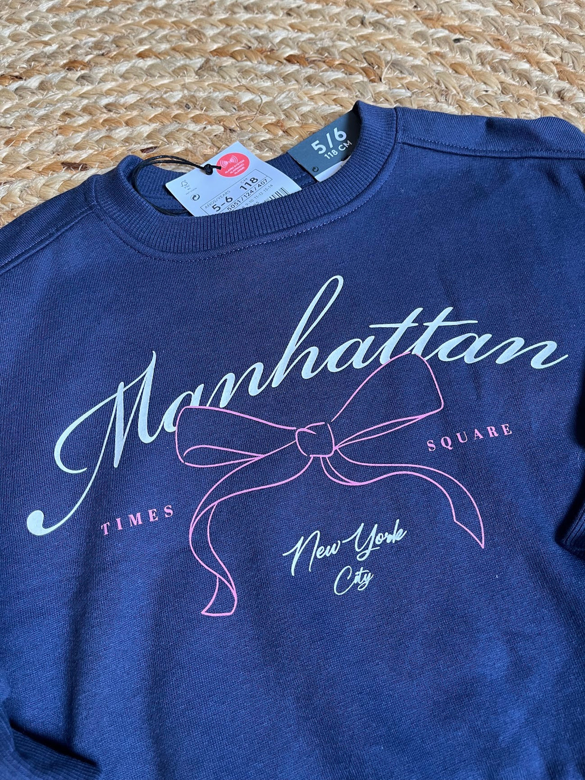 Polerón azul de niña Vamos Niños marca Lefties con estampado de lazo y texto Manhattan, talla 6, estilo casual.