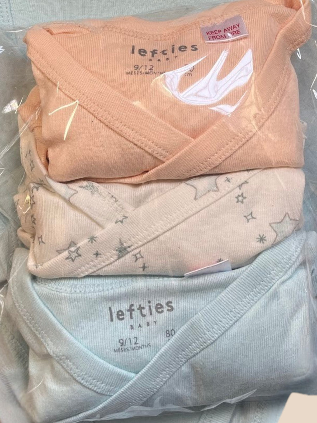 Set de 3 bodies unisex Vamos Niños en colores celeste, damasco y blanco con estampado de estrellas para bebé