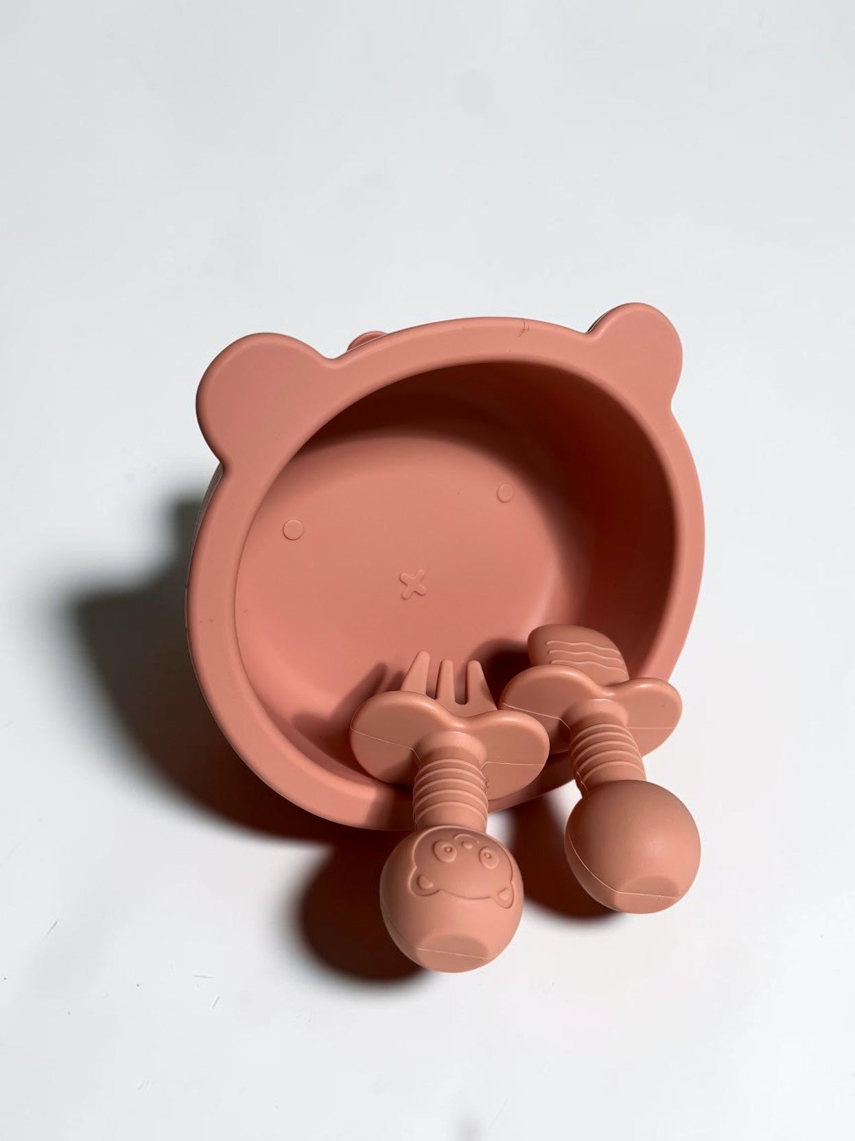 Set de alimentación Vamos Niños de silicona color rosa con cuenco y cubiertos ergonómicos en forma de osito.
