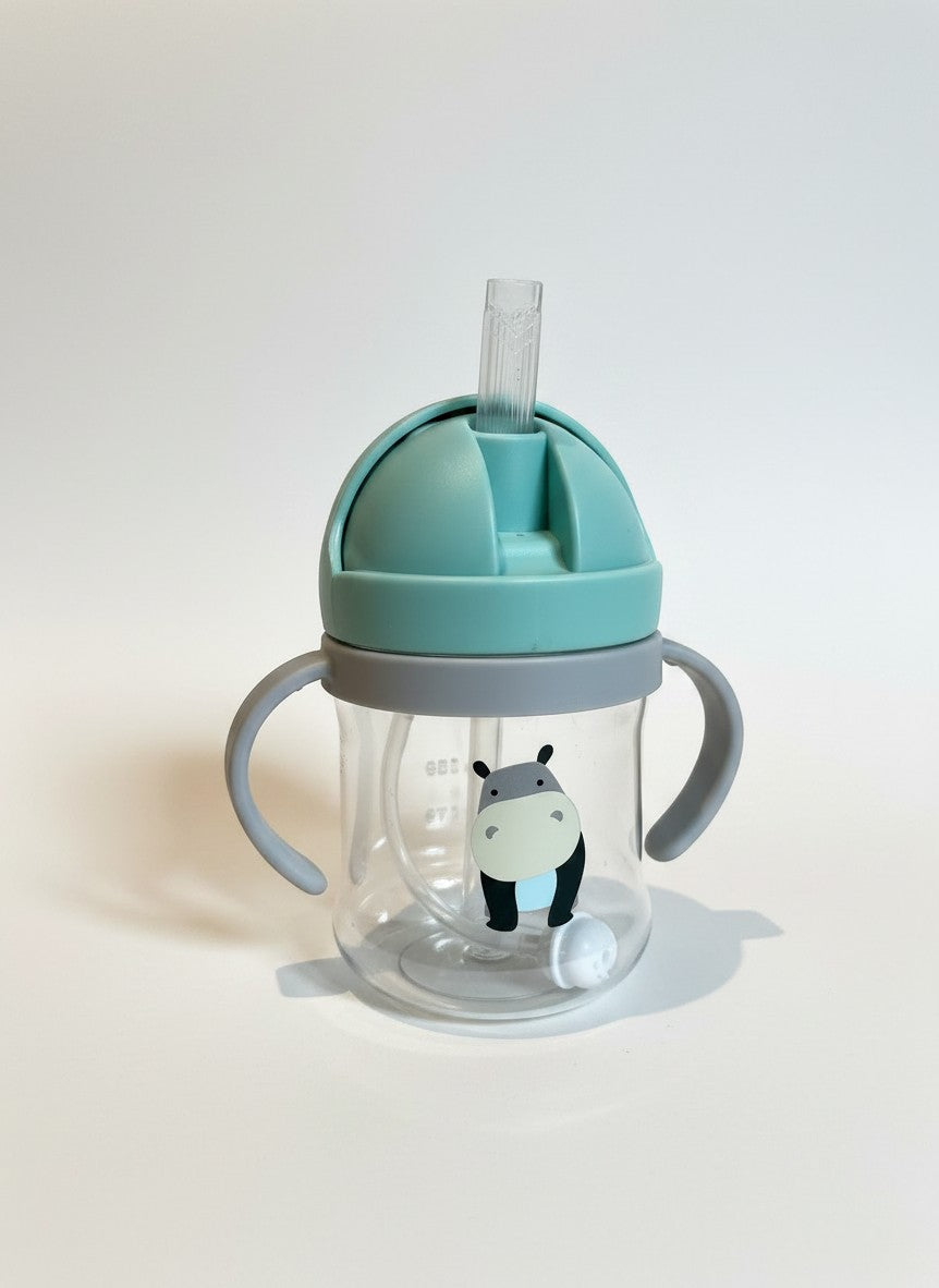 Vaso de aprendizaje Vamos Niños con pajita, asas ergonómicas, diseño de hipopótamo y tapa verde azulado sin BPA.